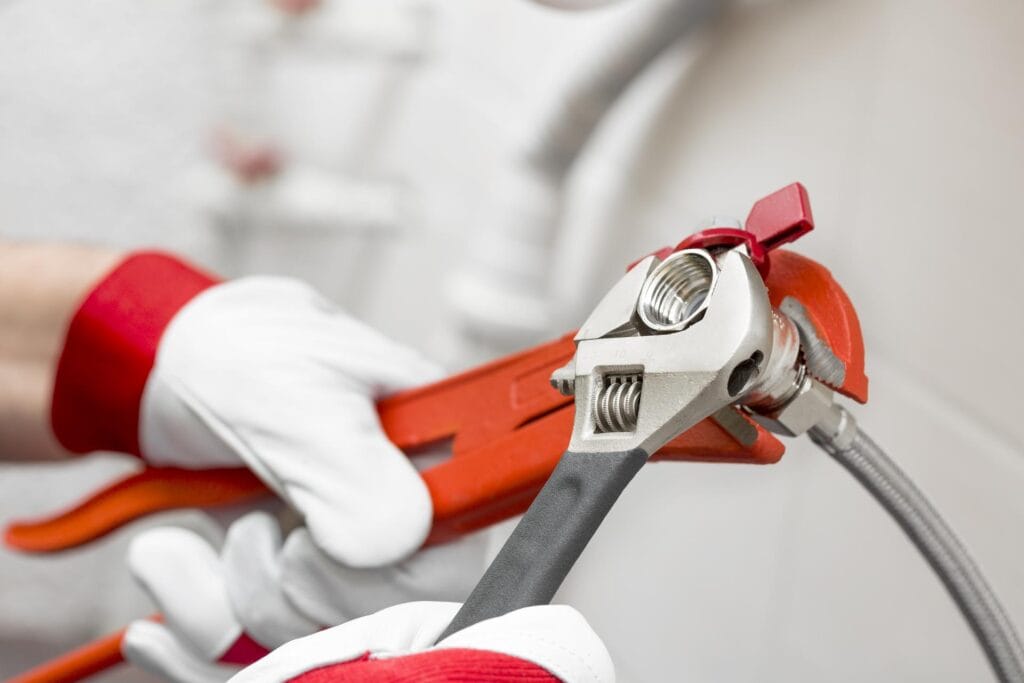 Plumber holding pipe wrenches for an emergency repair in West Palm Beach