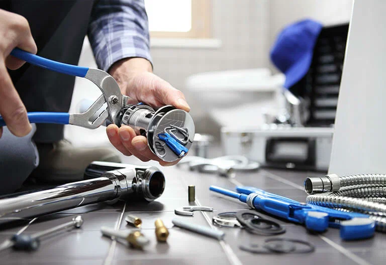Technician repairing a plumbing fixture with professional tools in West Palm Beach