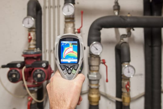 Plumber using a thermal imaging camera to inspect pipes in West Palm Beach