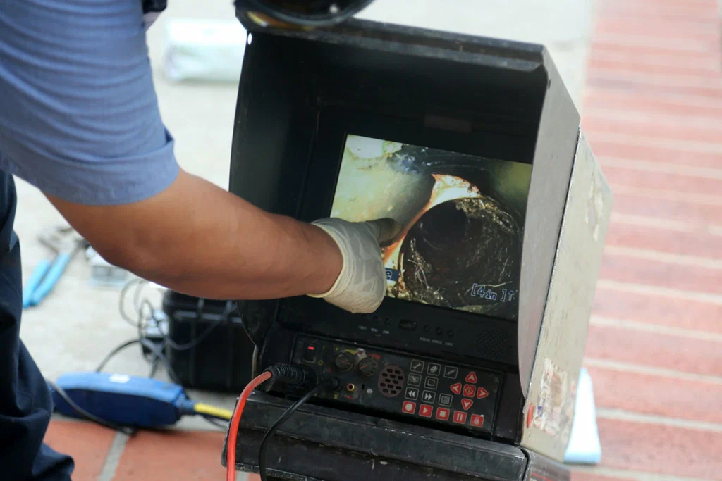 Technician viewing a drain inspection camera in West Palm Beach