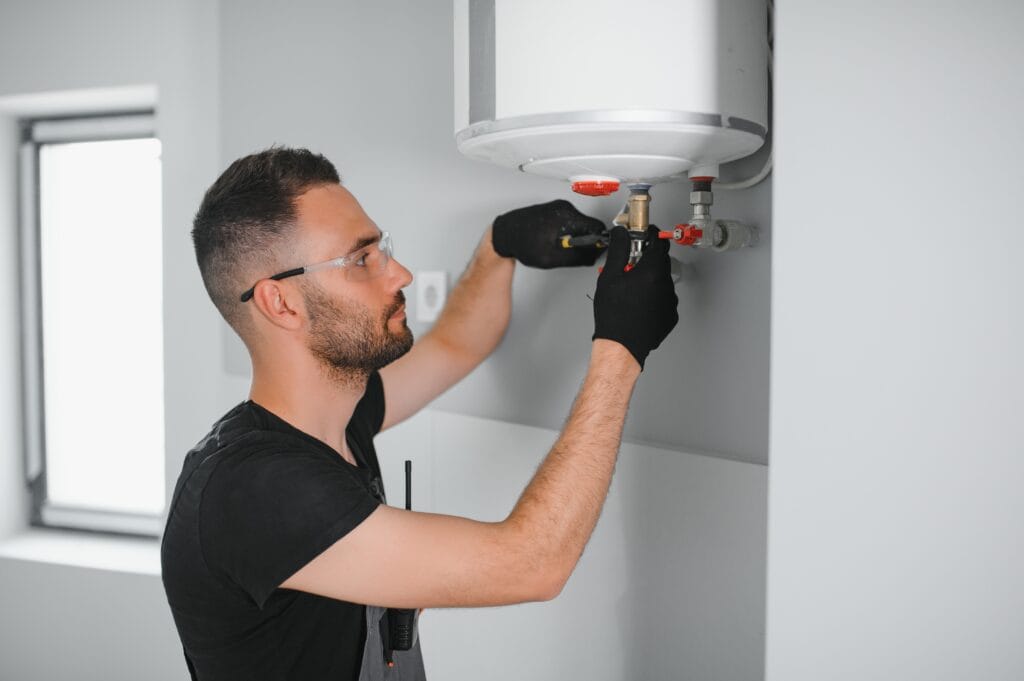Technician performing water heater maintenance in West Palm Beach