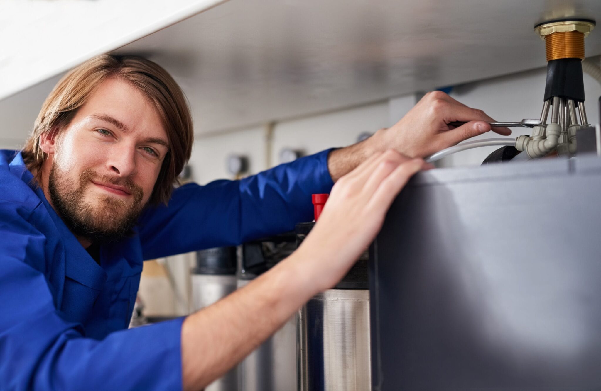 Technician servicing a residential water heater tank in West Palm Beach