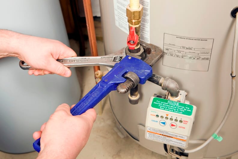 Plumber repairing a water heater valve in West Palm Beach